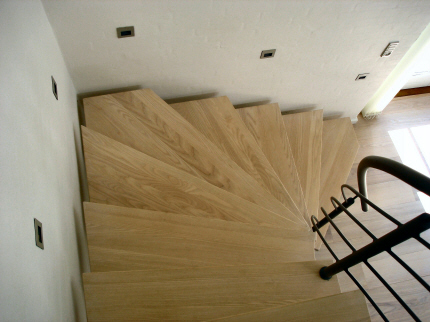 Opsadlet center ståltrappe: venstre-sving med faconskårede fyrplank trin. gelænderhåndliste, balustre, medløbere og trappevange pulverlakeret i standard RAL farve, koksgrå.