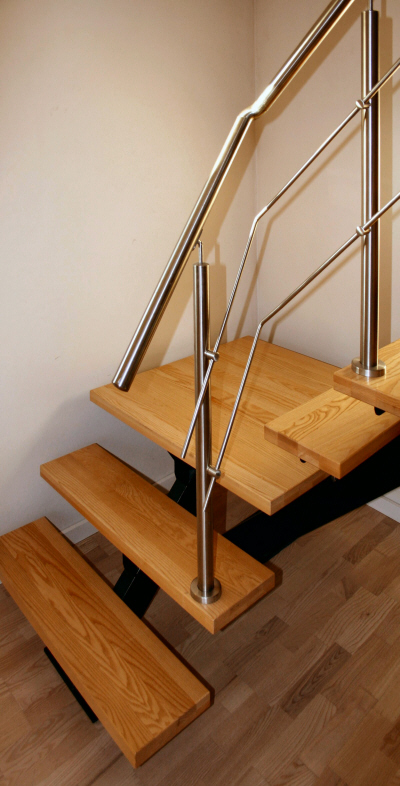 Indendørs opsadlet trappe med design gelænder + håndliste af rustfrit stål