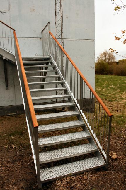 Ståltrappe med trappevanger af stålplade med påboltet gelænder med værn-udfyldning pr. 80 mm af 12mm rundstål.