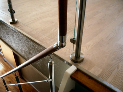 Crosinox rækværk, gelænder system: Førstesal påmonteret trappe gelænder, balustere af crosinox rustfrit stål system, medløbere af rustfri stål stænger, håndliste af 45 mm mahogny. Førstesal monteret med rækværk i crosinox system og lamineret sikkerhedsglas, med håndliste i sammenhæng med trappehåndliste.